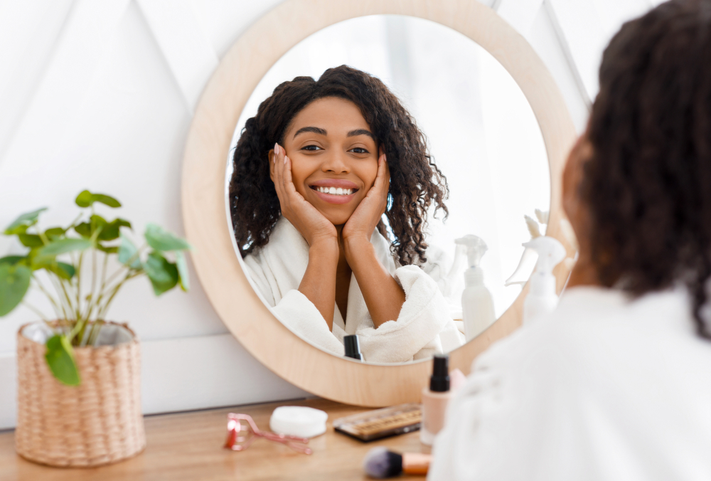 woman holding face in mirror