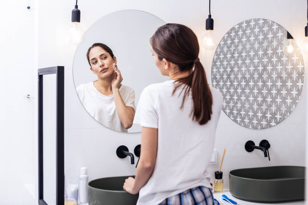 Woman applying toner to face