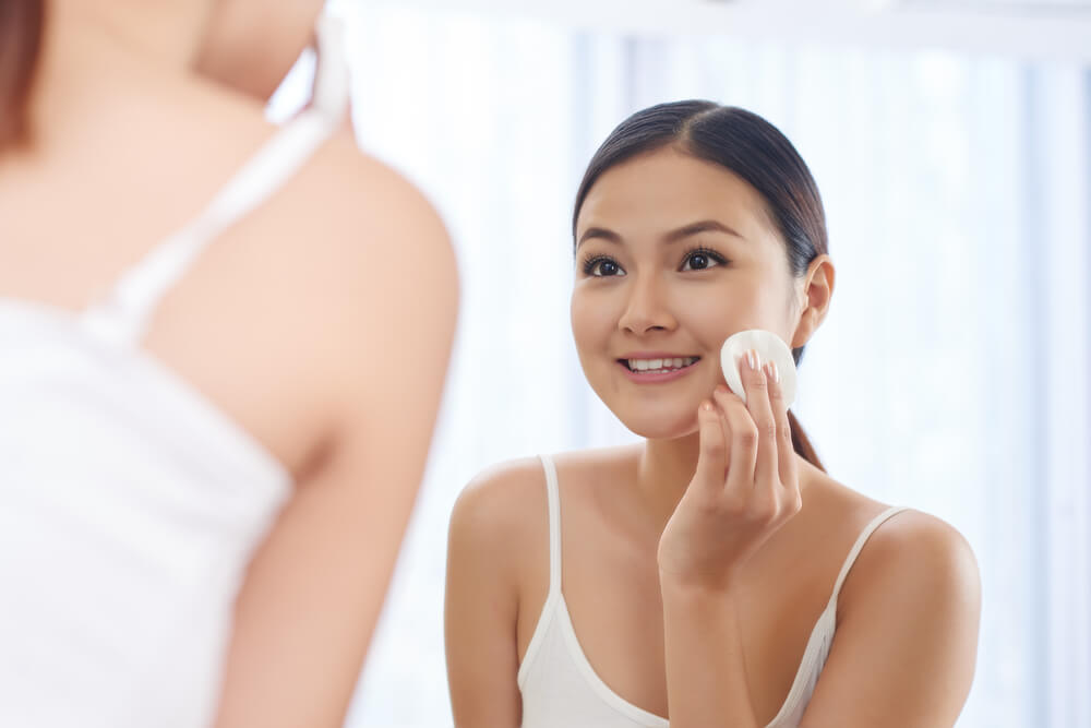 Woman applying toner to face