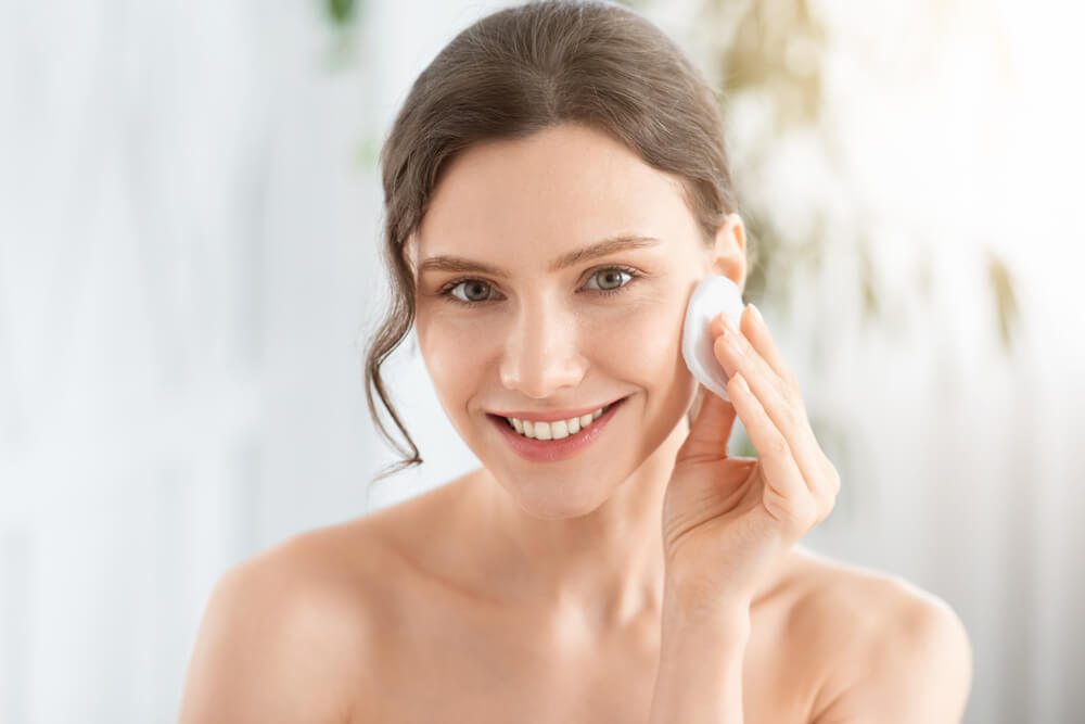 Woman applying toner to face