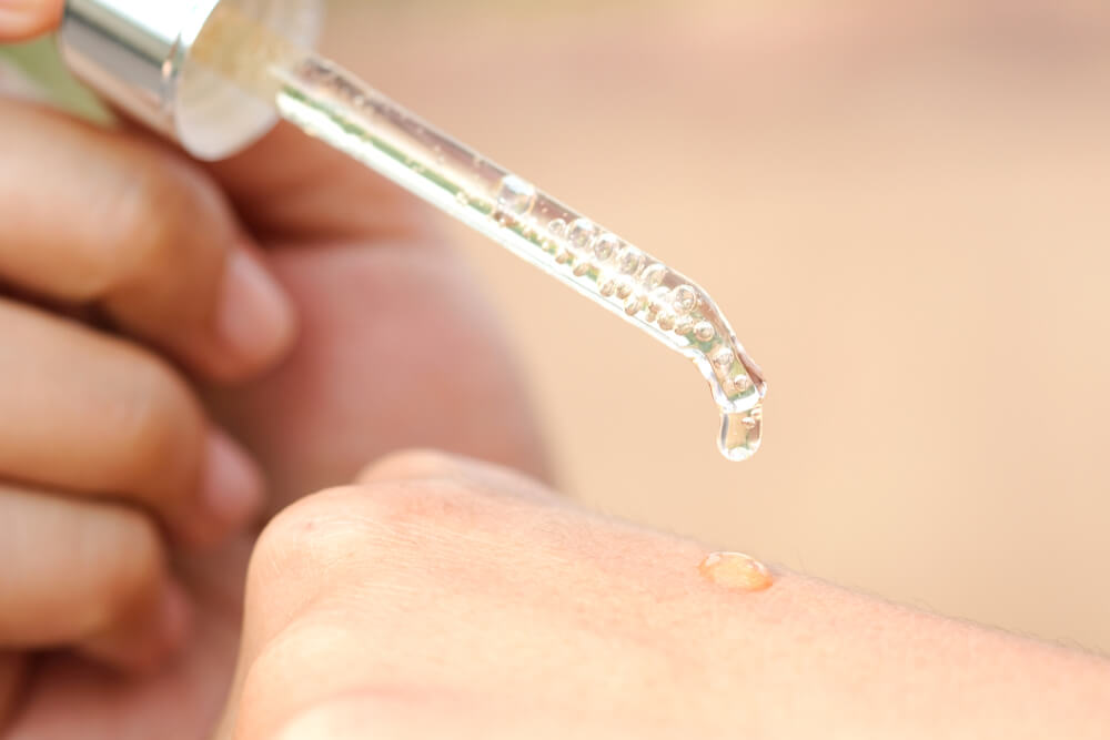 Woman applying serum to hand