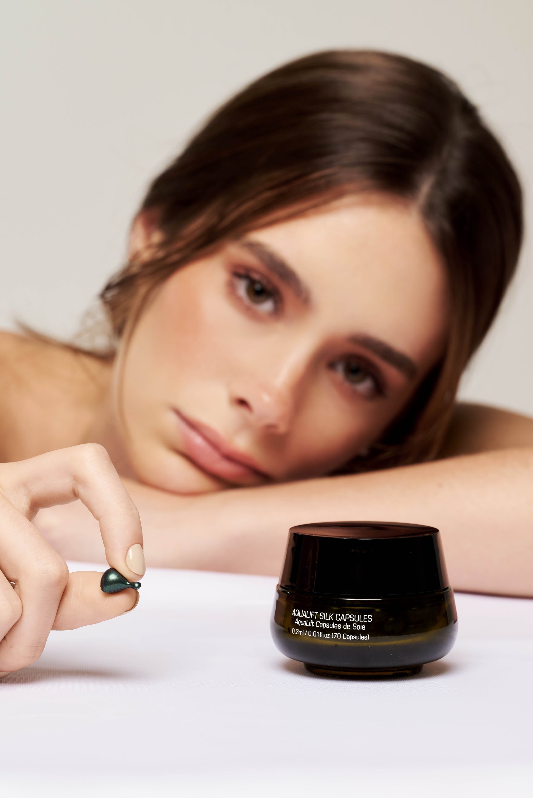 Woman holding a capsule from Introstem AquaLift Silk Capsules