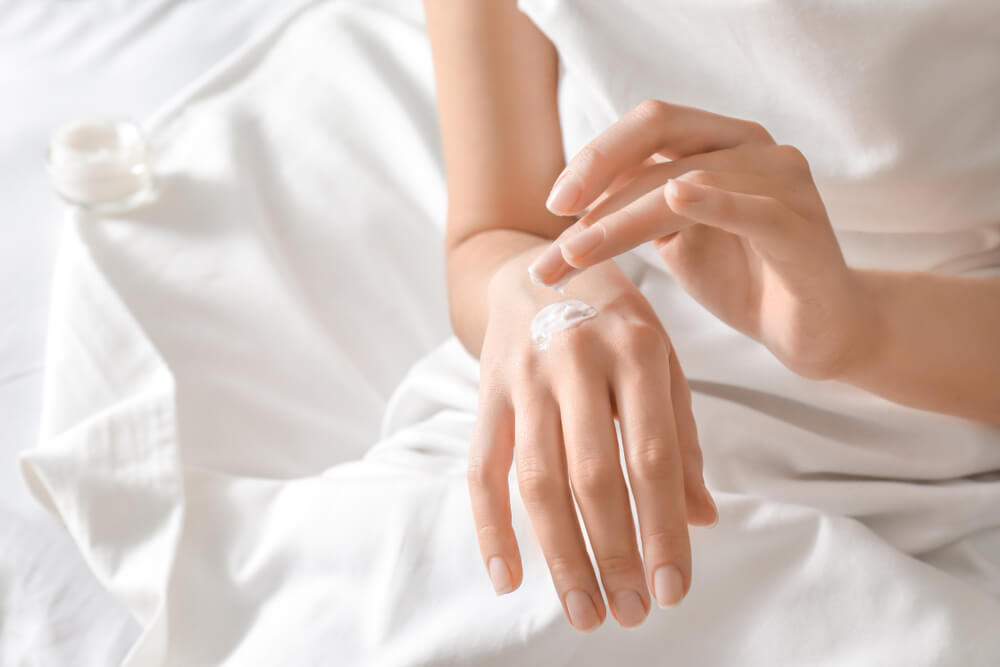 Woman applying hand creams from grapes