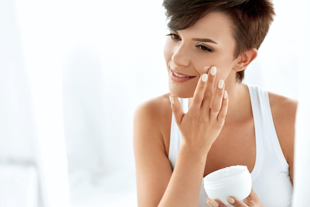 Woman applying face cream