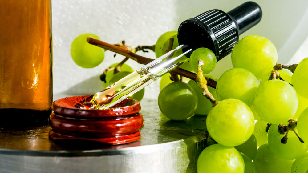 Grapes next to dropper with grape oil