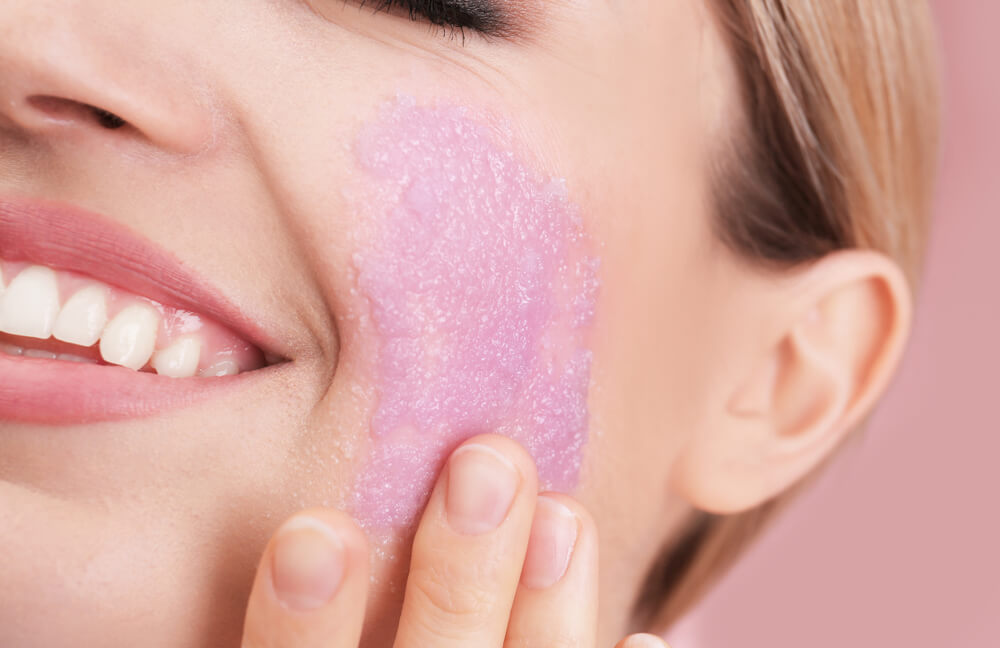 Woman using face scrub