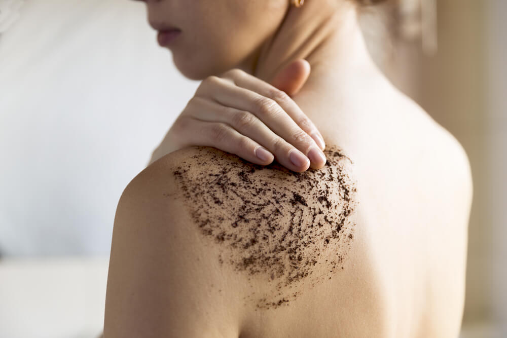 Woman using body scrub