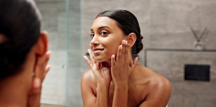 Woman looking at skin in mirror