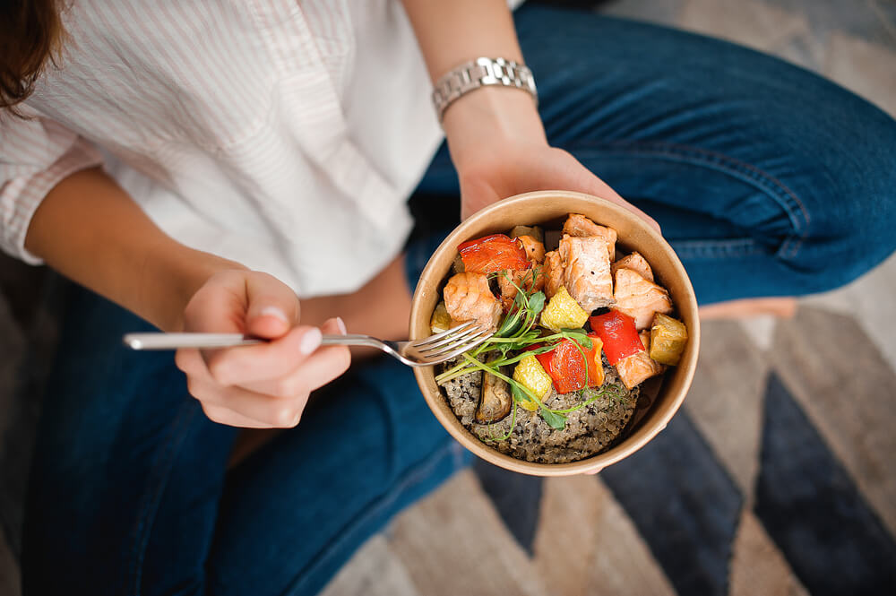 Woman eating bowl of healthy food