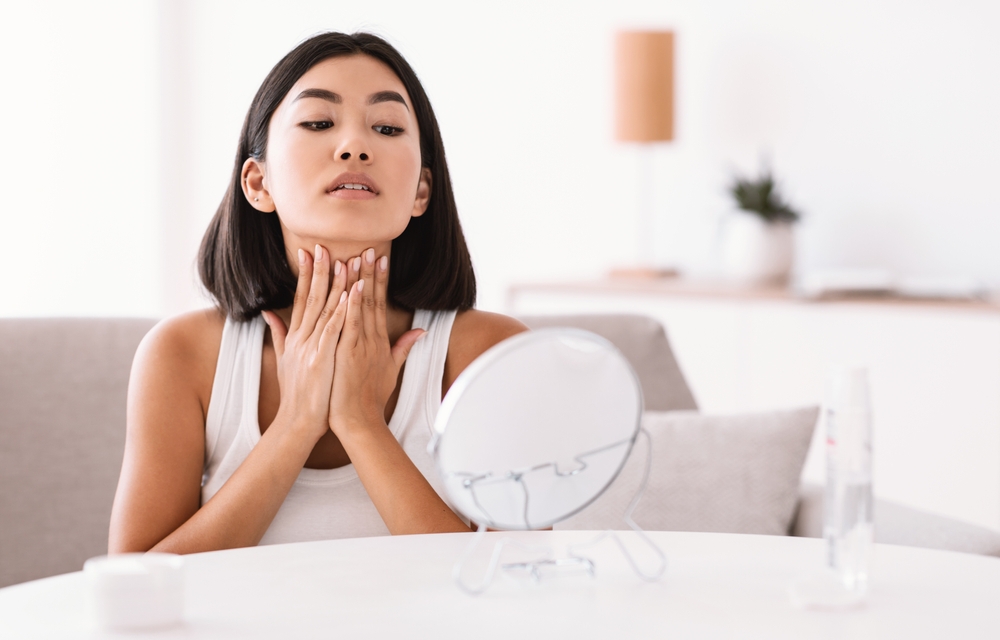 Woman looking at skin in mirror