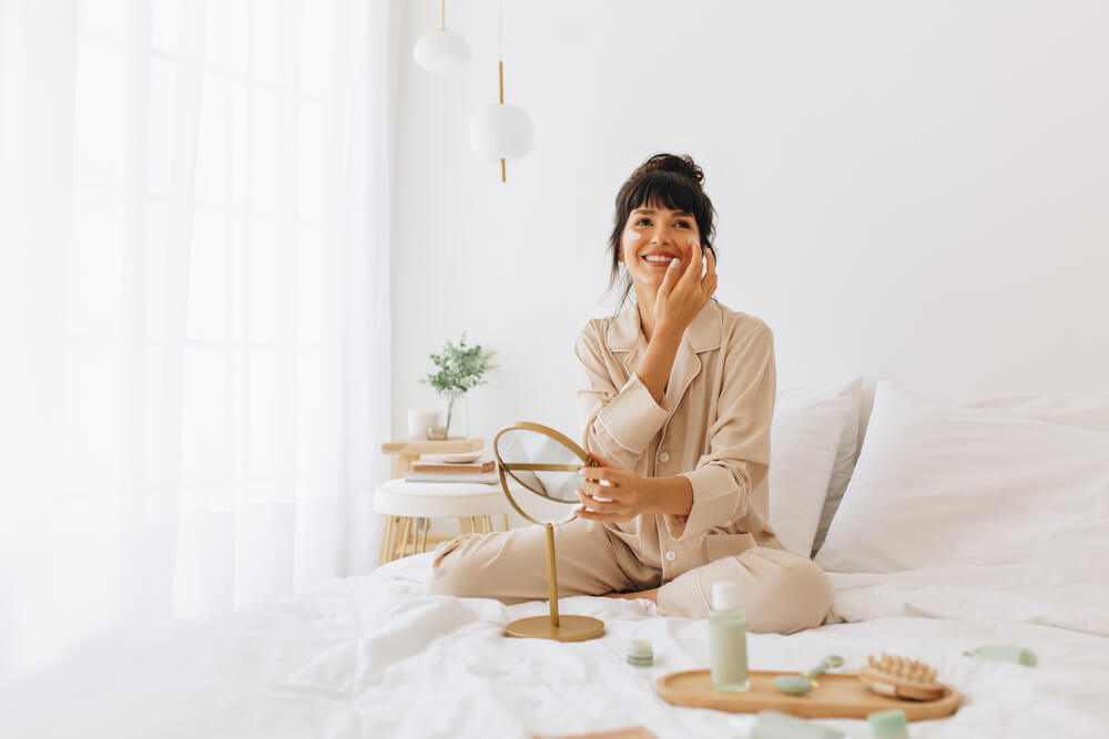 Woman applying face mask after reading Introstem reviews