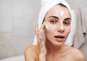 Woman using fatty acid skincare cream
