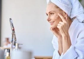 Woman applying cream after reading Introstem reviews
